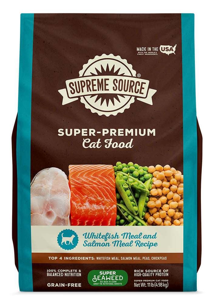A package of Supreme Source Super-Premium Cat Food with Whitefish Meal and Salmon Meal Recipe. The bag is predominantly brown and blue with images of whitefish and salmon, and it is labeled as grain-free.
