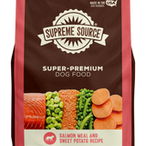 A package of Supreme Source Super-Premium Dog Food with salmon meal and sweet potato recipe. The bag is predominantly red and white, with images of salmon, sweet potatoes, and carrots on the front.