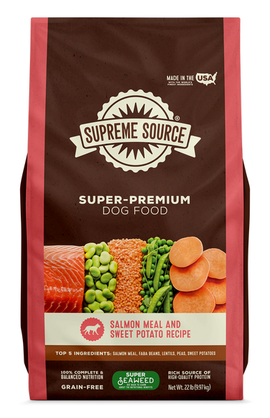 A package of Supreme Source Super-Premium Dog Food with salmon meal and sweet potato recipe. The bag is predominantly red and white, with images of salmon, sweet potatoes, and carrots on the front.