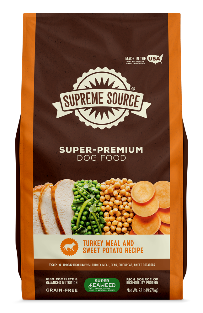 A package of Supreme Source Super-Premium Dog Food with Turkey Meal & Sweet Potato Recipe. The bag is predominantly brown with images of the product contents, which include turkey and sweet potatoes, displayed on the front.
